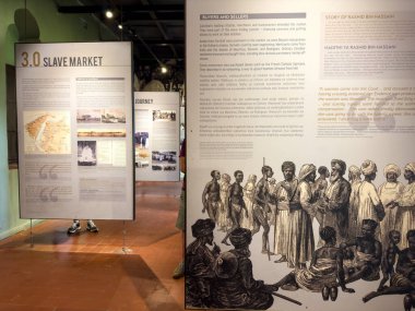 Doğu Afrika Köle Ticaret Fuarı, Taş Şehir, Zanzibar, Tanzanya 'da sergilenen bir sergiye bakan batılı bir kadın turist görülüyor.