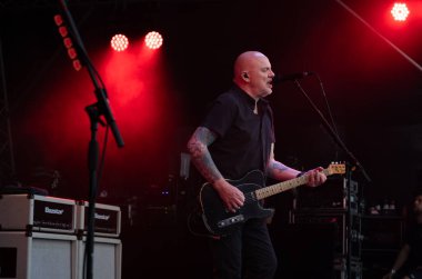 Guildford / UK - Jun 29 2024: Baz Warne sings and plays guitar with The Stranglers at Guilfest music festival, Guildford, Surrey, UK. clipart