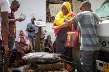 Bir kadın, Tanzanya 'nın Zanzibar kentindeki Stone Town Market' ten sarı yüzgeçli ton balığı (Thunnus albacares) alır.