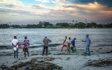 Hamallar, akşamları Kivukoni Balık Pazarı, Dar es Salaam, Tanzanya 'da geleneksel ahşap dhow teknelerinden yakaladıkları balıkları boşalttıktan sonra torba dolusu balıkla koşuyorlar.,