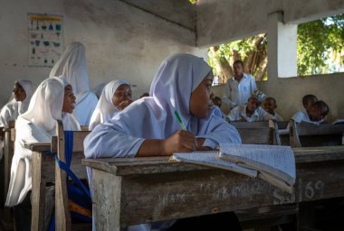 Jambiani, Zanzibar, Tanzanya 'daki Jambiani Ortaokulu' nda İngilizce dersinde Müslüman bir kız ve diğer erkek ve kadın öğrenciler..
