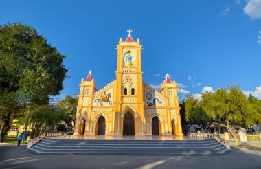 A front view of the yellow decorated Catholic Tan Huong Church, in Kontum, in the Central Highlands of Vietnam. clipart