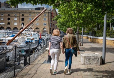 Lezbiyen bir çift, Londra 'nın doğu yakasındaki tarihi St. Katherine rıhtımında el ele yürüyor..