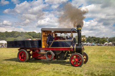 Parham / UK - Jul 13 2024: Enthusiasts drive a 1920 Clayton and Shuttleworth overtype steam wagon at Sussex Steam Fair, Storrington, UK. clipart