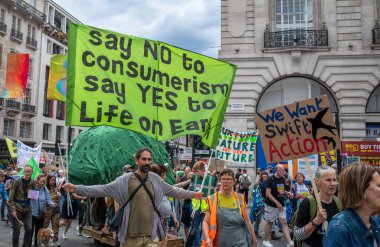 Londra / İngiltere - 22 Haziran 2024: Bir iklim aktivisti, Çevre Koruma için Doğayı Yenileme Yürüyüşü 'nde anti-tüketim pankartı tutuyor. RSPB, WWF, National Trust, Extinction Rebellion gibi kuruluşlar 