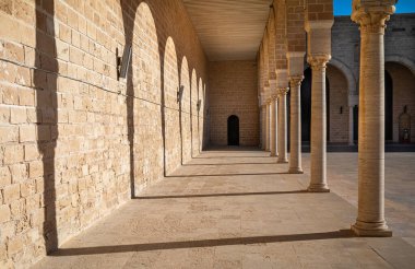 Geleneksel İslami at nalı kemerlerinin gölgeleri sahilin kenarında, ya da avluda, Tunus 'taki Mahdia Büyük Camii' nde..