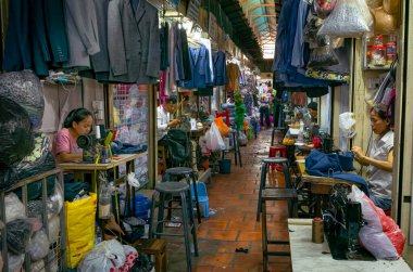 Terziler ve terziler Phnom Penh, Kamboçya 'daki Rus pazarının içinde bir koridorda çalışıyorlar..