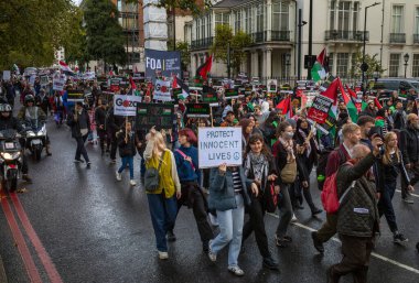 Londra / İngiltere - 21 Ekim 2023: Filistin yanlısı protestocular, İsrail 'in Londra merkezindeki Gazze saldırısına karşı düzenlenen gösteride pankartlar ve bayraklarla yürüdüler.