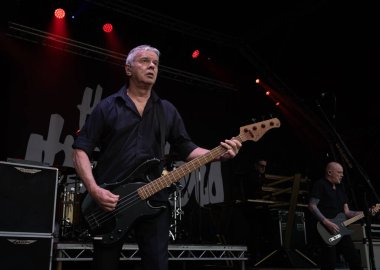 Guildford / UK - Jun 29 2024: Original band member Jean-Jacques Burnel performs with The Stranglers at Guilfest music festival, Guildford, Surrey, UK. clipart