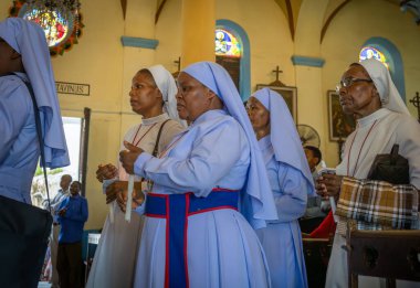 Katolik rahibeler Aziz Joseph Katedrali 'ne girerken mum tutarlar Taş Şehir, Zanzibar, Tanzanya' daki Katolik Pazar Ayini için..