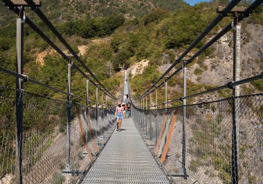 Fransız Alpleri, Mayres-Savel, Isere, Fransa 'da Monteynard Gölü üzerinden Passerelle du Drac Köprüsü' nü (Drac Footbridge) geçen insanlar...