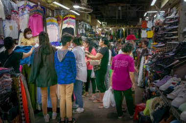 Kamboçya 'nın Phnom Penh kentindeki Rus Marketi' ndeki bir tezgahta alışveriş yapan bir kalabalık giysileri didik didik ediyor..