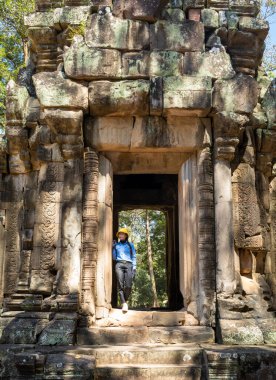 Phimeanakas tapınağının yanında görevli bir kadın güvenlik görevlisi ve Kamboçya 'daki Angkor kompleksi içinde kraliyet hamamı..