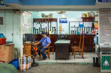 Vietnam, Danang 'daki Con Market' te üniformalı bir güvenlik görevlisi ofisindeki bir bilgisayara bakıyor..