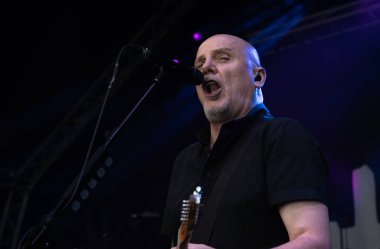 Guildford / UK - Jun 29 2024: Baz Warne sings and plays guitar with The Stranglers at Guilfest music festival, Guildford, Surrey, UK. clipart