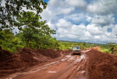 Tanzanya kırsalında Msanga yakınlarındaki ıslak ve çamurlu bir toprak yoldan geçen 4 tekerli bir araç..