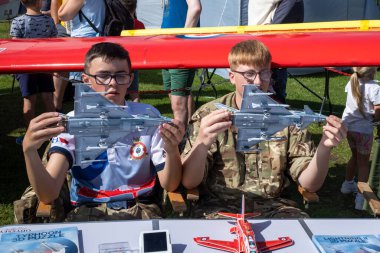 Askeri üniformalı iki genç Hava Harp Okulu öğrencisi Tayfun uçaklarını her yıl düzenlenen Eastbourne Havaalanı 'nın yanındaki askeri sergide sergiliyorlar.