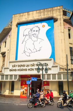 Vietnam 'ın devrimci lideri Ho Chi Minh' in dev portresi Hanoi, Vietnam 'daki eski Trang Tien Postane binasında bir çocuğu tutuyor..