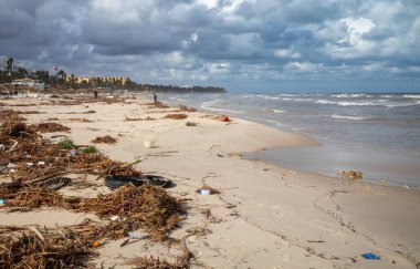 Samara Sahili 'ndeki Sousse, Tunus' taki her şeyi kapsayan tatil beldelerinin önüne rüzgârın savurduğu şemsiyeler altında kalan çöpler ve diğer döküntüler..