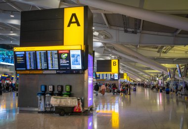 Londra 'daki Heathrow Havaalanı Terminali 5' in kalkış salonundaki kontrolde bilgi panoları ve bölge işaretleyicileri..