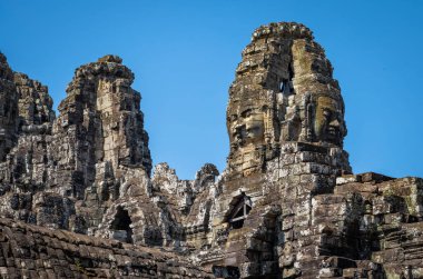Angkor Thom 'daki Angkor Kamboçya' daki antik Bayon Tapınağı 'nın taşına oyulmuş dev yüzler..