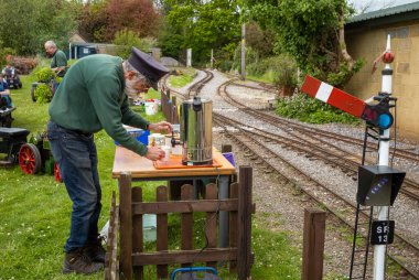 Bir gönüllü Güney Downs Light Railway, Pulborough, İngiltere 'deki sıcak su vazosundan çay yapıyor.