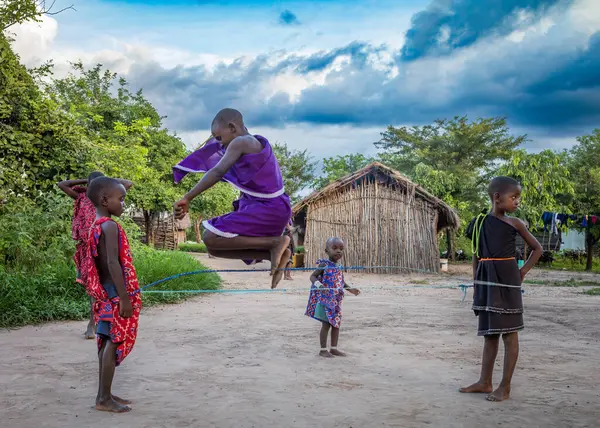 stock image Young Maasai children play a skipping and jumping game in their traditional village in Mikumi, Tanzania.