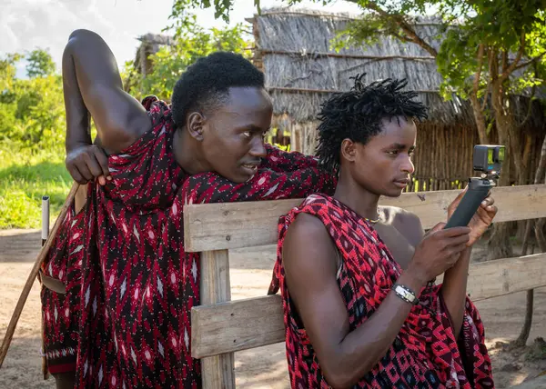 stock image Two young Maasai warrior tribesman look at a GoPro video camera in Mikumi, Tanzania