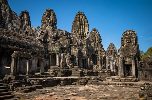 stock image A courtyard looked down on by giant stone faces in the Bayon Temple at Angkor Thom near Angkor Wat in Cambodia.