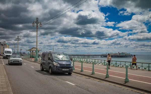 Brighton, Doğu Eussex, İngiltere 'deki Brighton İskelesi yakınlarındaki sahil şeridinin yanındaki Kings Road boyunca trafik sürüyor..