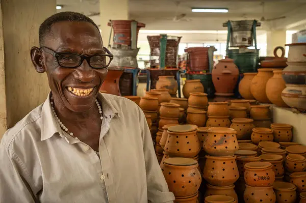 Doğu Afrika 'da Tanzanya' daki Dar es Salaam 'da Kisutu Market' teki tezgahında geleneksel kömürle çalışan bir adam duruyor.