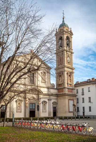 stock image A rank of BikeMi electric bicycles for hire outside the catholic St Stefano Maggiore church, Milan, Italy. The church is used by the Filipino community in the city