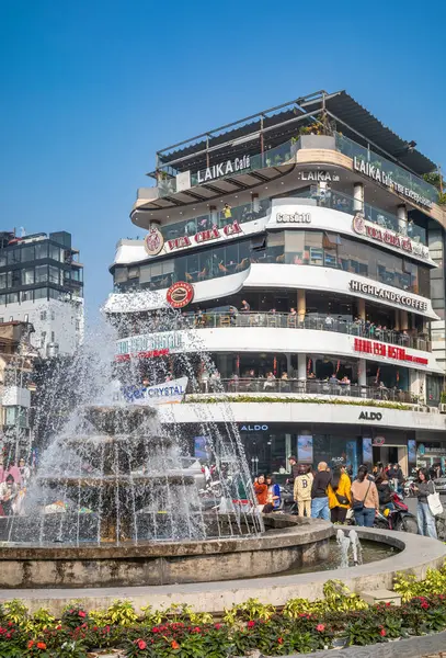 Çeşme ve Dong Kinh Nghia Thuc Meydanı 'ndaki kafelerle dolu bir bina Hoan Kiem Gölü, Hanoi, Vietnam.