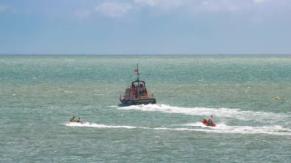 stock image Two inflatable rescue ribs accompany Tamar class lifeboat RNLI 16-23 off the coast from Eastbourne, East Sussex, UK.