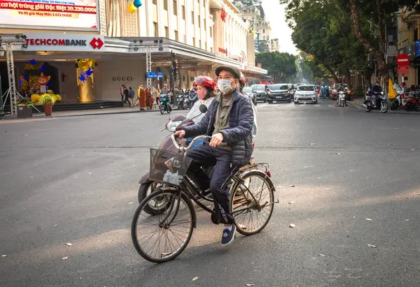 Yaşlı Vietnamlı bir adam Hang Bai 'de bisikletine biniyor, Hanoi, Vietnam' daki Hoan Kiem gölünün yanında.