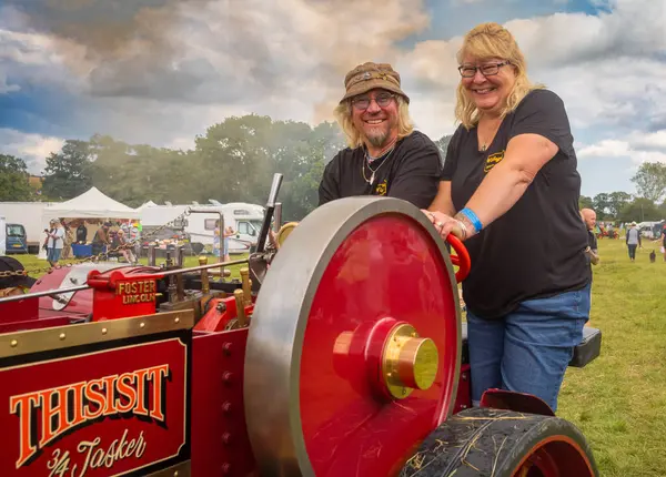 stock image Storrington / UK - Jul 13 2024: Steam enthusiasts drive their scale model steam traction engine at Sussex Steam Fair, Parham, Storrington, UK.