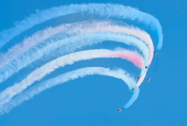 stock image The world famous RAF display team The Red Arrows release red, blue and white smoke as they perform along the seafront at the annual Eastbourne Airbourne, an international airshow