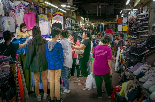 stock image A crowd of shoppers rummage through clothes on a stall within the Russian Market in Phnom Penh, Cambodia.