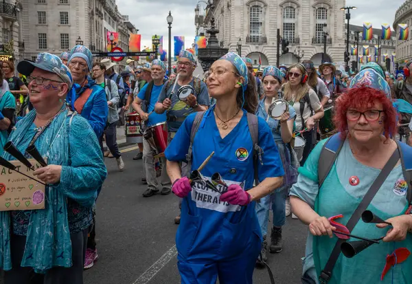 Stock image London / UK - Jun 22 2024: Climate activists play percussion at the Restore Nature Now march for environmental protections. Organisations including the RSPB, WWF,  National Trust, Extinction Rebellion and others united for the march.