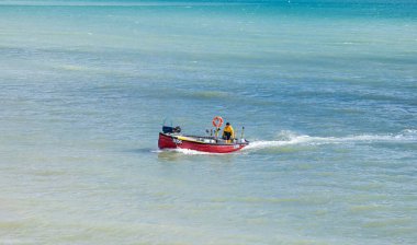 Yalnız bir balıkçı, geleneksel ahşap balıkçı teknesini İngiltere 'nin Bognor Regis plajına götürür..