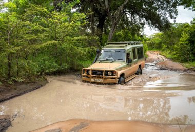 Tanzanya 'daki Nyerere Ulusal Parkı' ndaki (Selous Game Reserve) safaride sel baskınında bir araç sürüyor.