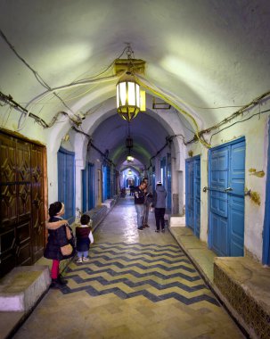 Çocuklar Kairouan, Tunus 'un Medine' sindeki antik örtülü çarşıda durup bekliyorlar. Kairouan İslam 'ın dördüncü en kutsal şehridir ve UNESCO' nun Dünya Mirasları Alanıdır..