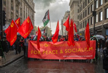 London / UK - Oct 21 2023: Members of the Communist Party of Britain (CPB) march in the rain with red flags and thousands of pro-Palestinian protesters at a mass demonstration against Israeli attacks on Gaza in central London, UK. clipart