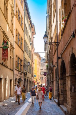 İnsanlar Fransa 'nın eski şehri Lyon' un göbeğindeki kadim dar kaldırımlı bir sokakta yürüyorlar..