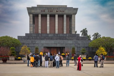 Bir grup Asyalı turist, başkent Hanoi 'deki Vietnamlı komünist lider Ho Chi Minh' in mumyalanmış cesedinin bulunduğu granit mozolenin önünde duruyorlar..