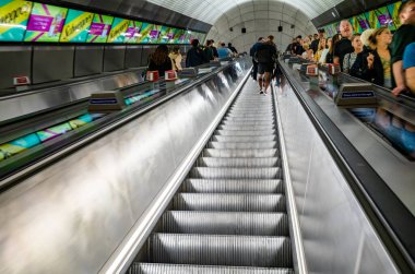 Yolcular, Londra 'nın en yeni alt sınırı olan Elizabeth Hattı' ndaki Liverpool Street istasyonunda yürüyen merdivenlere biniyorlar..