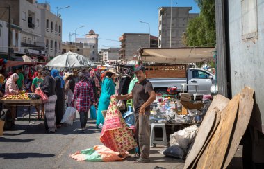 Pazar günü Sousse, Tunus 'ta haftalık pazarda plastik masa giysileri satan bir adam var..