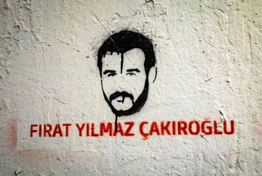 Stenciled street art showing the face and name of Frat Yilmaz akrolu, an 