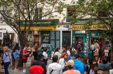 İnsanlar Paris, Fransa 'daki Seine nehrinin sol kıyısındaki dünyaca ünlü İngilizce kitapçısı Shakespeare and Company' ye girmek için kuyruğa giriyorlar..