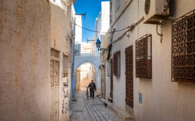 Tunuslu bir adam bisikletini Tunus 'un antik Medine' si Kairouan 'da dar bir patikadan aşağı itiyor. Kairouan İslam 'ın dördüncü en kutsal şehridir ve UNESCO' nun Dünya Mirasları Alanıdır..